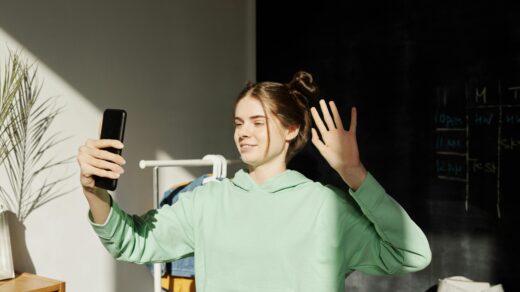 Teenager in hoodie using phone