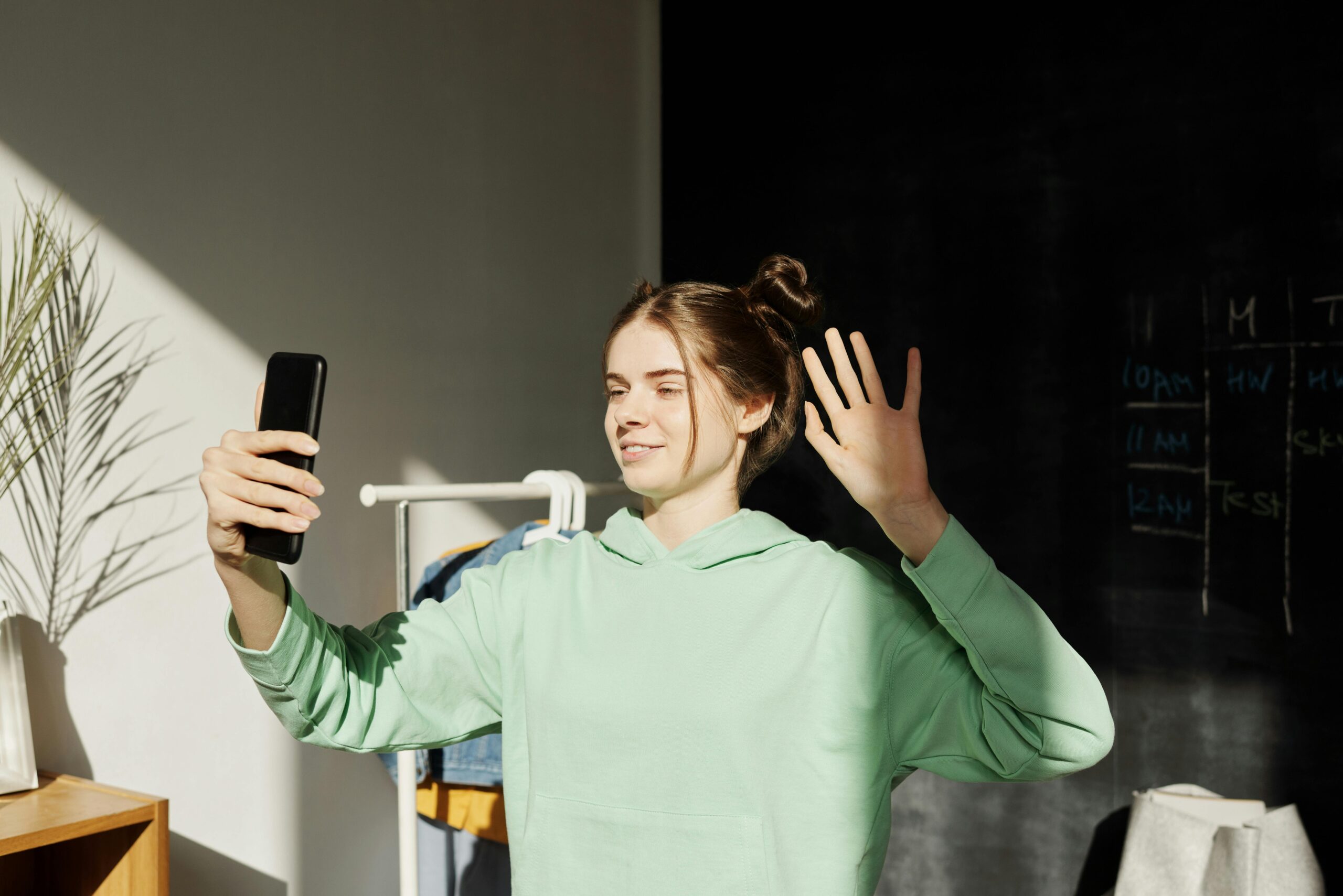 Teenager in hoodie using phone