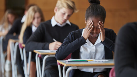 Anxious Teenage Student Sitting Examination In School Hall