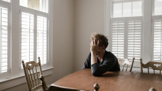 Sad young person sitting at table