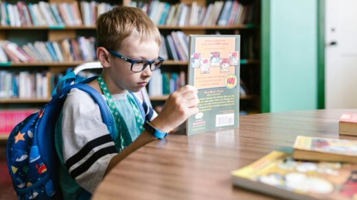 Child with glasses reading a book