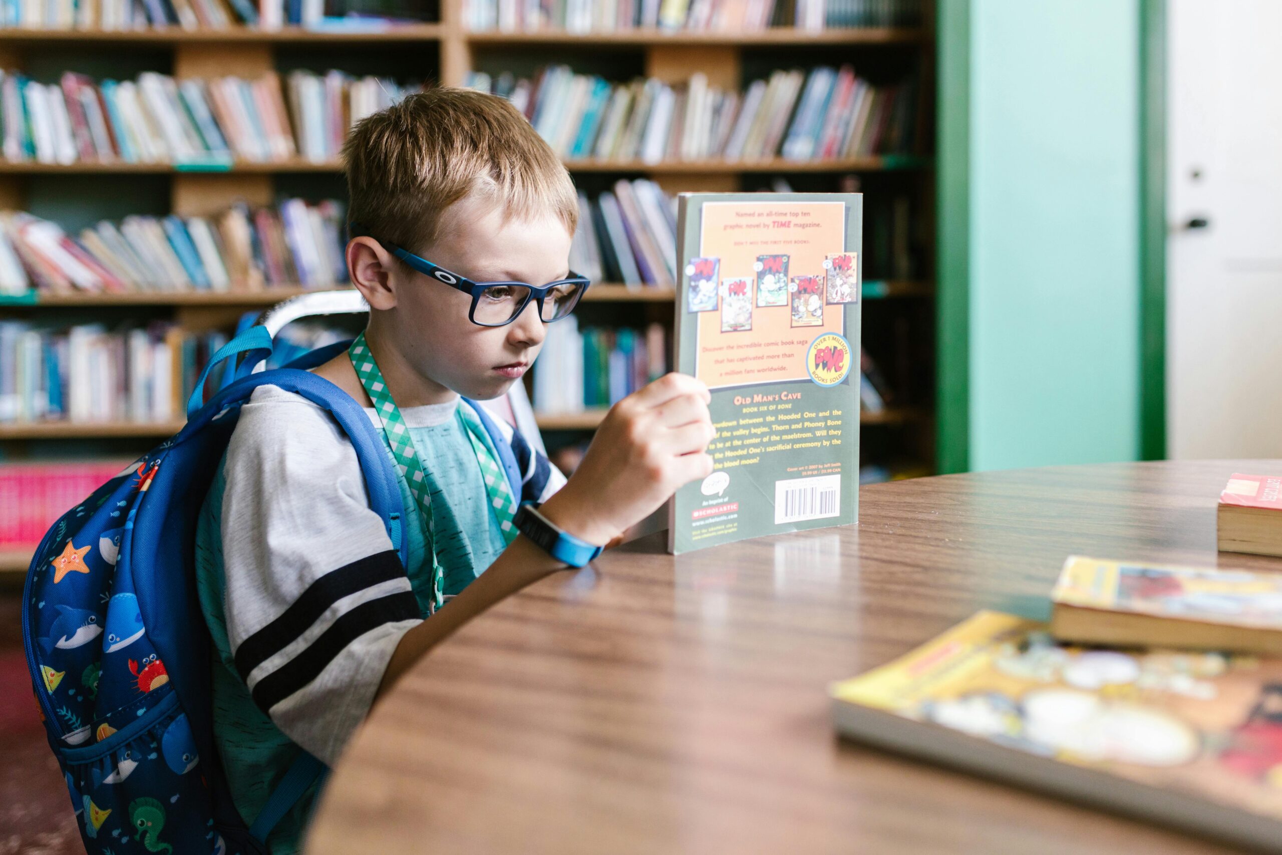 Child with glasses reading a book