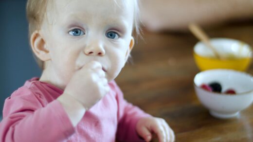 Toddler at table with bowl of food