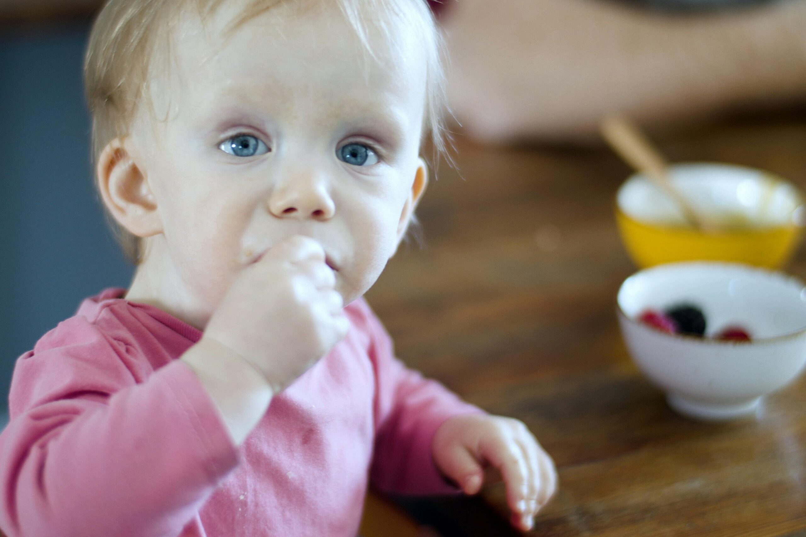 Toddler at table with bowl of food