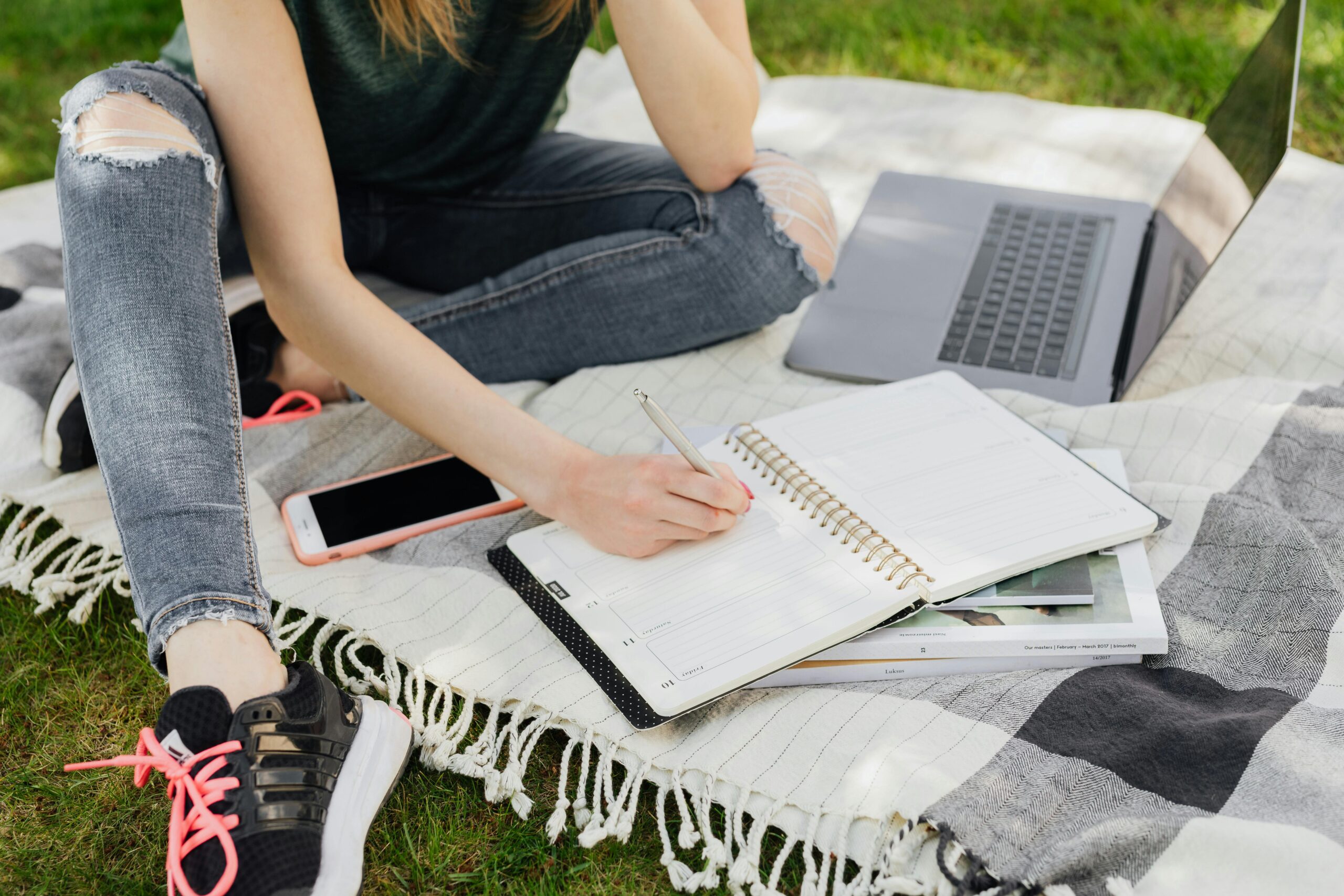 Teen on laptop writing in planner